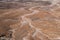 Aerial view of a vast barren desert landscape with an abstract pattern of dry stream beds