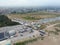 Aerial view of vehicles parked on a dirt road, situated in front of a large open field