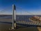 Aerial view of the Verrazzano-Narrows Bridge on a sunny day with a barge and ferry passing by.