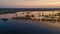 Aerial view of vessel engaged in dredging at sunset time. Ship excavating material from a water environment