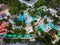Aerial view of a vibrant scene of an aqua park from above, where people enjoy slides and pools. Laughter and joy fill