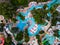 Aerial view of a vibrant scene of an aqua park from above, where people enjoy slides and pools. Laughter and joy fill