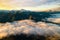 Aerial view of vibrant sunrise over white dense fog with distant dark Carpathian mountains on horizon