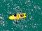 Aerial view view of strong young active men capsizing with their kayak on the clear blue ocean.