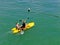 Aerial view view of strong young active men kayaking on the clear blue turquoise water of the ocean.
