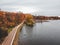 Aerial view walking path along the lake, colorful autumn forest. St. Petersburg, Russia