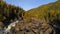 Aerial view of waterfall, flying over autumn forest, waterfall with big stones