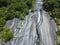 Aerial view of a waterfall in Val di Mello, a green valley surrounded by granite mountains and woods. Val Masino, Sondrio. Italy