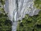 Aerial view of a waterfall in Val di Mello, a green valley surrounded by granite mountains and woods. Val Masino, Sondrio. Italy