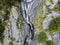 Aerial view of a waterfall in Val di Mello, a green valley surrounded by granite mountains and woods. Val Masino, Sondrio. Italy