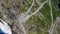 Aerial view of waterfalls and traffic on Trollstigen or Trolls Path, a popular serpentine mountain road with 11 hairpin turns.