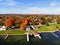 The aerial view of the waterfront residential area surrounded by striking fall foliage by St Lawrence River