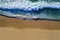 Aerial view of a wave breaking at the shore of the Comporta Beach.