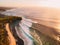 Aerial view of waves at warm sunset and tropic beach. Ideal ocean waves for surfing in Bali