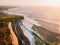 Aerial view with waves at warm sunset and tropical beach. Ideal ocean waves for surfing