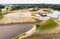 Aerial view of a wet quarry for gravel and sand with large machines for excavation and processing.