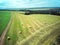 Aerial view wheat field with straw bales, road and forest