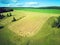 Aerial view wheat field with straw bales, road and forest