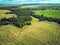 Aerial view wheat fields with straw bales, road and forest