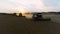 Aerial view of wheat three silhouette of harvests. Drone shot flying over three combine harvesters working on wheat