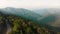 Aerial view white car travels in beautiful mountainous terrain. One car driving on an asphalt road