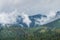 Aerial view of white fluffy clouds dancing in lush green mountains in Washoe Valley, Nevada