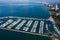 Aerial view of a white motor yacht. Yacht enters the bay in the parking lot. Many different yachts, catamarans moored to piers.