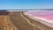 Aerial view of White salt on the shores of the island in Pink Island and blue sky . Lake Lemuria, Ukraine. Lake