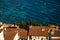 Aerial view of whitewashed houses with red tiles rooftops and sea