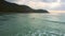 Aerial view wide long ocean waves and distant surfer