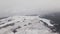 Aerial view of a wind farm in winter, rotating turbines on a snowy field in Ukraine