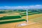 Aerial view of wind turbine. Windmills at harvest time, fields from above. Agricultural fields on a summer day. Renewable Energy