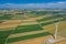 Aerial view of wind turbine. Windmills at harvest time, fields from above. Agricultural fields on a summer day. Renewable Energy