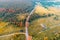 Aerial view of winding brook, country road, and fields