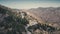 Aerial view winding motorway in mountains. Rocky sandy hills and trees. Cinematic drone flight