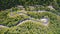 Aerial view of winding road with cars at sunny day in summer