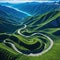 An aerial view of a winding road cutting through mountains or a coastal depicting