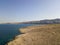 Aerial view of a winding road that runs along the Croatian coasts, dirt road, island of Pag near Rucica beach in Metajna. Croatia