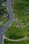 Aerial view of the winding Transfagarasan road near the green meadow with the sheep grazing