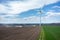 Aerial view on the windmill and the tractors harrowing the field