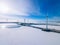 Aerial view of windmills with blue frozen river in snow winter Finland. Wind turbines for electric power