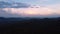 Aerial view of windmills farm for energy production on mountain with cloudy sky.