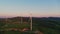 Aerial view of windmills standing on green field