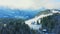 Aerial view of winter cedar forest in ArvenbÃ¼el, Amden. Piste and chalets uphill