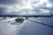 Aerial view of a winter curved road covered with snow. A snowy plateau with single trees captured from above with a