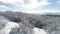 The aerial view of winter forest on heights of the birds flight against bright, blue, cloudy sky. Shot. Beautiful