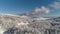 The aerial view of winter forest on heights of the birds flight against bright, blue, cloudy sky. Shot. Beautiful