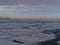 Aerial view of winter landscape with valley of snow-covered textured fields, country road and town Rottenburg am Neckar, Germany.