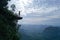 Aerial view of woman on the edge of the rock on the mountain view point