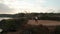 Aerial view of woman taking break after exercising on sea shore cliff at sunrise